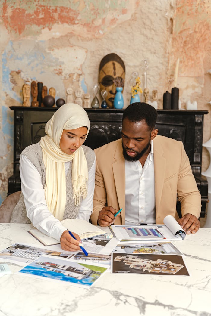 Two professionals reviewing documents in a creative workplace. Focus on collaboration.